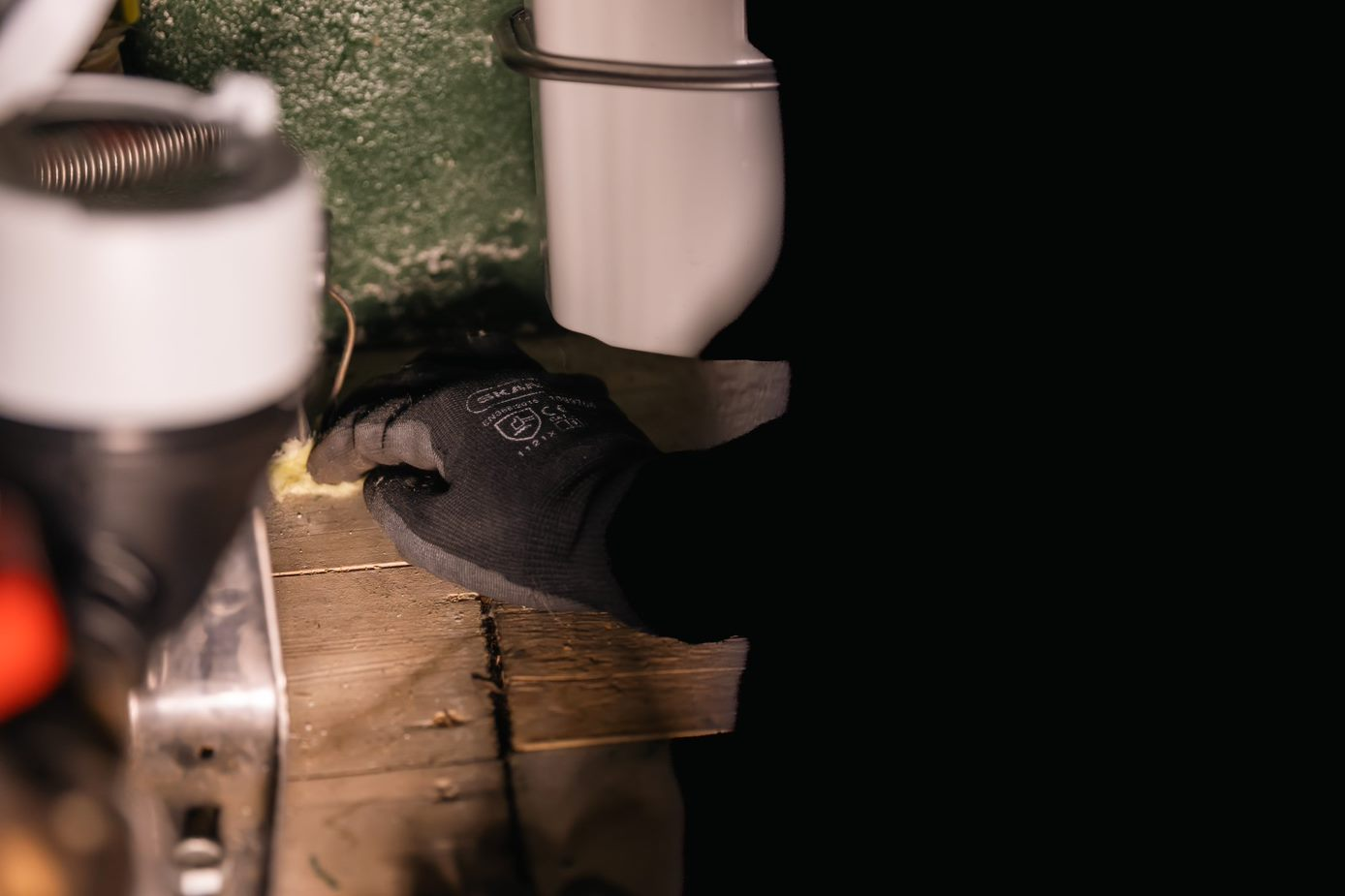 Vrouw plaatst vezelmateriaal bij een leiding.