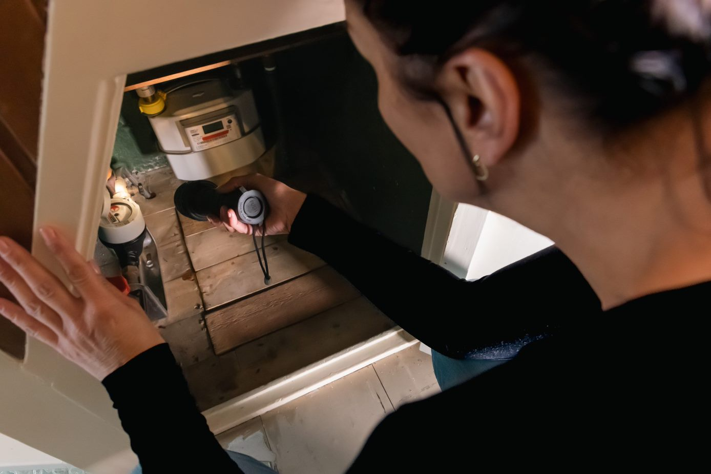 Vrouw kijkt of er ruimte rond haar leiding zit.